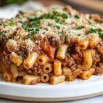 A steaming bowl of beefaroni topped with fresh parsley.