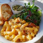 Mac and cheese served with a green salad and garlic bread on a dining table